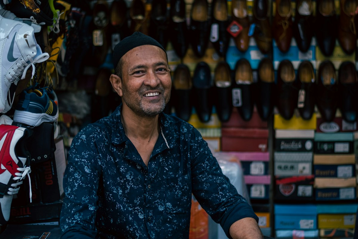 A small business shop owner smiling in his shop