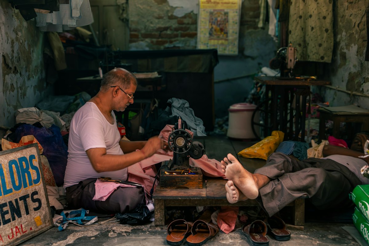An artisan working at a sewing machine in his workshop