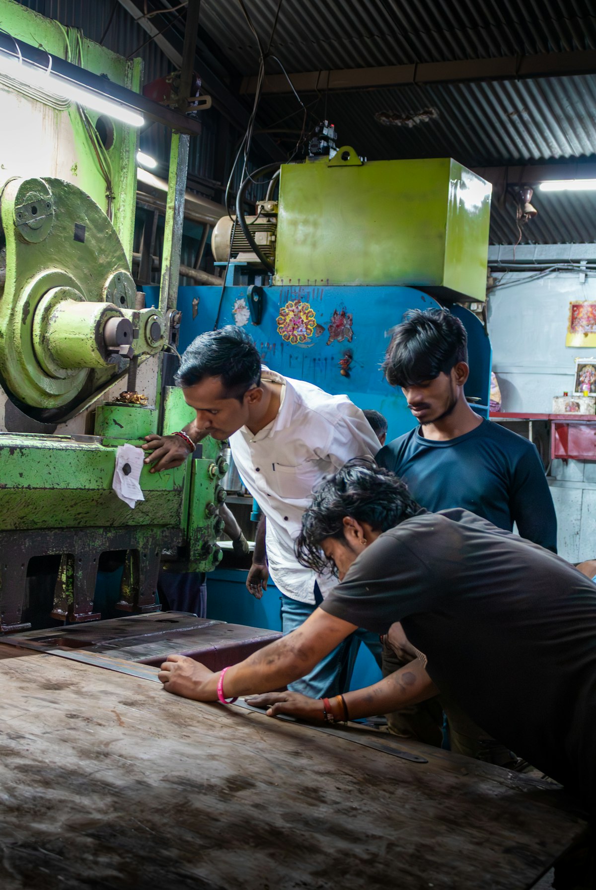 Workers operating industrial manufacturing machinery